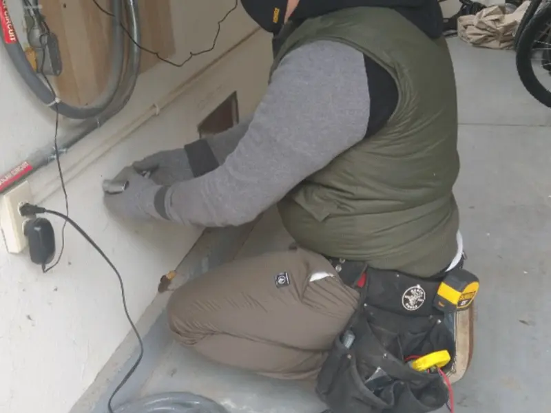 Electrician performing outlet wiring in a Wallburg garage